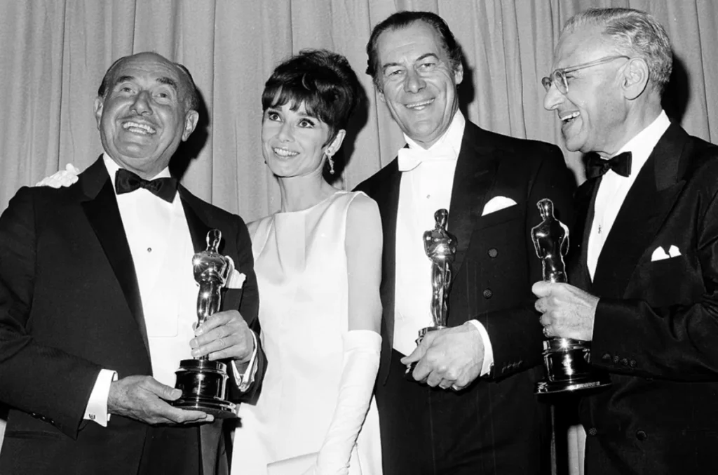 Jack Warner, Audrey Hepburn, Rex Harrison y George Cukor en la 37ª edición de los Premios Óscar en 1965