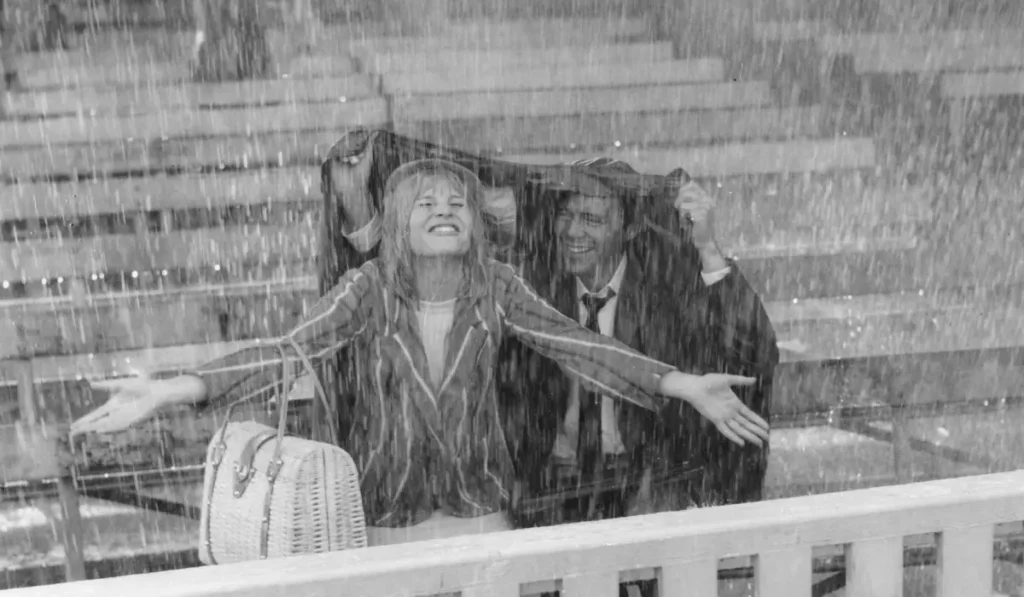Julie Christie (Diana Scott) aparece bajo una lluvia torrencia junto a Dirk Bogarde