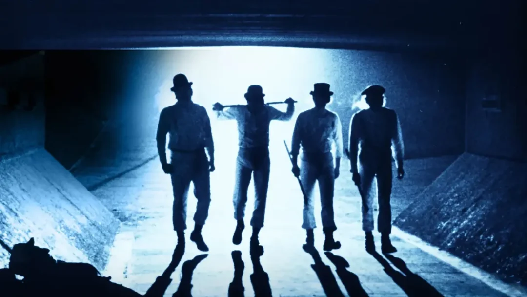 Escena de los "drugos" apareciendo en un túnel antes de apalear a un mendigo