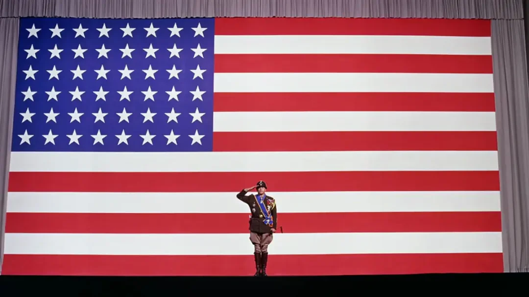 El general Patton en su discurso inicial frente a la bandera americana.