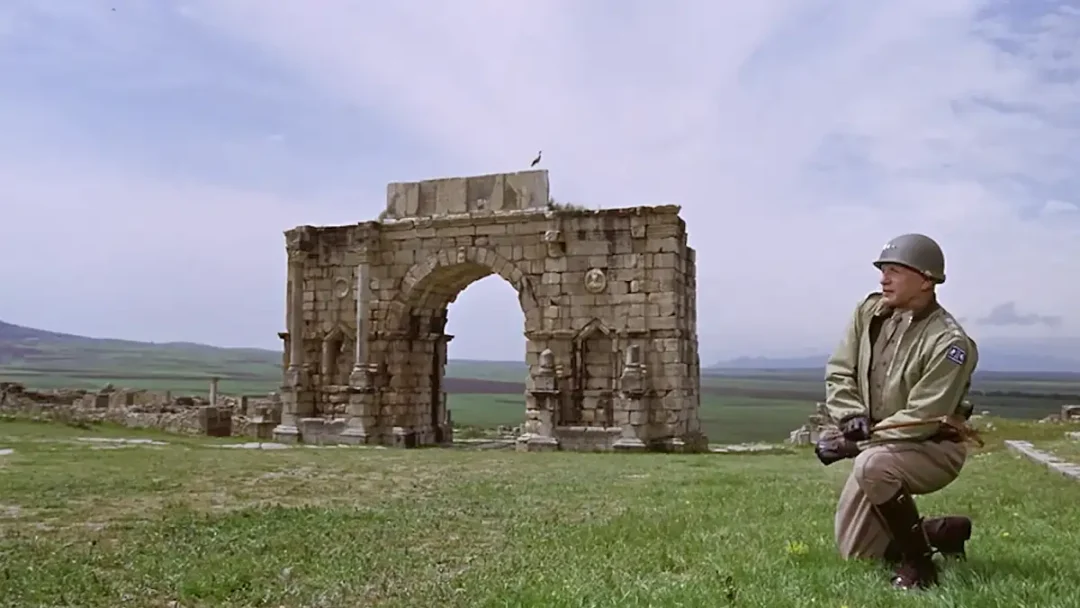 Patton se arrodilla en Arco de Caracalla en las ruinas romanas de Volubilis, Marruecos.